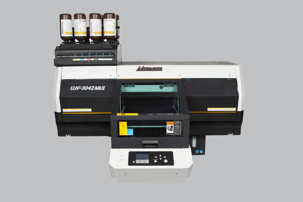Mimaki UJF-3042MKII UV-LED Kompakt Fachbettdrucker vor grauem Hintergrund